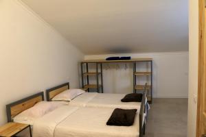 2 aparte bedden in een kamer met witte muren bij Chalet Pkhelshe in Kazbegi