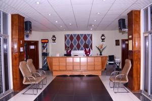 a lobby with a desk and chairs in a building at Beausejour Hotel in Kigali