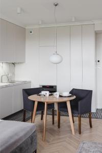 a room with a table and two chairs and a kitchen at LuxLux Apartments Metro Slodowiec in Warsaw