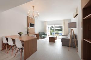 a dining room and living room with a table and chairs at Hotel La Pergola Mallorca in Port d'Andratx