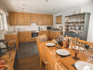 a kitchen with wooden cabinets and a wooden table with chairs at The Brewhouse in Doddington