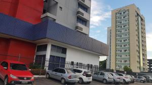 eine Gruppe von Autos, die vor einem Gebäude geparkt sind in der Unterkunft Apartamento Manaus Arena da Amazonia in Manaus