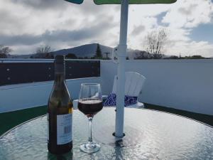 a bottle of wine and a glass on a table at The Heart of Rotorua in Rotorua