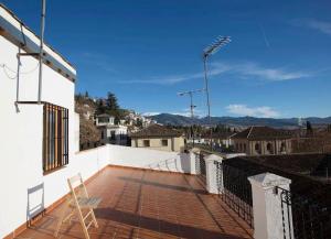a balcony of a white house with a roof at Realejo Príncipe in Granada