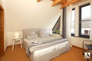 a bedroom with a large bed in a room with windows at Kapitaensweg 15 in Ostseebad Karlshagen