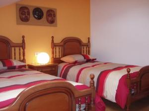 1 dormitorio con 2 camas y reloj en la pared en Ático nuevo en playa de Laxe, en Laxe