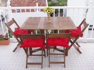 una mesa de madera con sillas y un jarrón de flores en Ático nuevo en playa de Laxe, en Laxe