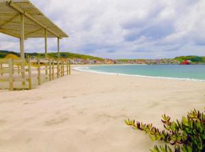 ラシェにあるÁtico nuevo en playa de Laxeの木造の桟橋と海のビーチ