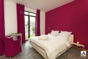 una camera da letto con un grande letto con pareti viola di Kapitaensweg 15 a Ostseebad Karlshagen
