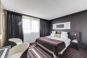 聖埃爾布蘭的住宿－LE COLISÉE Hotel & Spa NANTES Saint Herblain，配有一张床和一把椅子的酒店客房