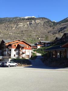 オレルにあるAppartement 2 pieces Orelle les trois Vallées 6 personnesの車を背景に山を背景にする町