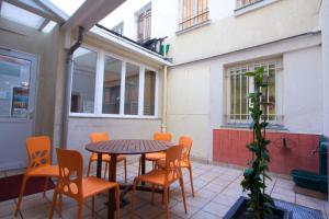 un patio con tavolo, sedie e piante di Bastille Hostel a Parigi