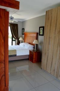 um quarto com uma cama e uma porta de madeira em Shalimar B&B em Table View