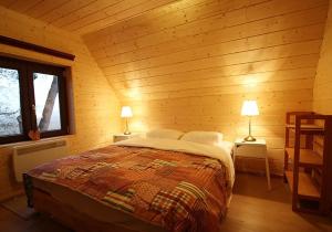 ein Schlafzimmer mit einem Bett in einer Holzhütte in der Unterkunft Dunaparti Ház Stand u 27E in Mosonmagyaróvár