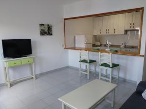 アレシーフェにあるApartamento Malvasía Vvのキッチン(カウンター、テレビ付)が備わる客室です。