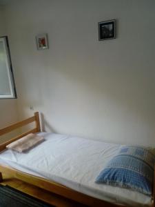 a bed in a bedroom with two pictures on the wall at setenčić in Trebinje +12 photos