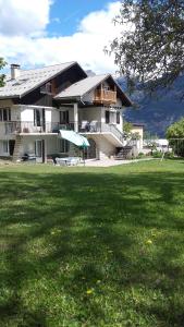ein großes Haus mit Rasen davor in der Unterkunft La Grande Lauze in Champcella