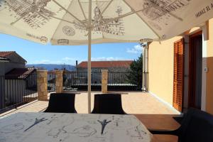 a table and chairs under an umbrella on a patio at Apartments Laura in Pinezici