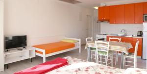 a small room with a bed and a kitchen at Apartments Laura in Pinezici