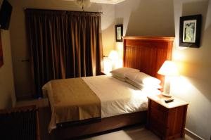 1 dormitorio con 1 cama y 2 lámparas en una mesita de noche en Shalimar B&B, en Table View