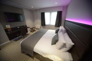 a hotel room with a bed with a purple lighting at Bannatyne Hotel Durham in Durham