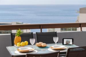 Una mesa con un plato de comida en un balcón. en Casa Branca Apartments by TrIp2Portugal, en Funchal