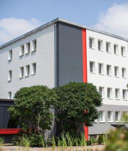 a white building with a red stripe on it at SKYBASIC Merseburg in Merseburg