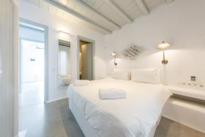 a white bedroom with a large white bed at Villa Maera 2 in Kalo Livadi