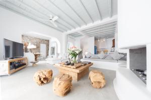 a living room with white furniture and wooden logs at Villa Maera 2 in Kalo Livadi