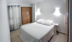 プエルト・デ・ラ・クルスにあるIriarte Serenity with FREE PARKINGのベッドルーム(白いベッド1台、窓付)