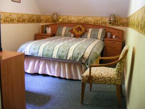 1 dormitorio con 1 cama, vestidor y silla en The Prince's House Hotel, en Glenfinnan