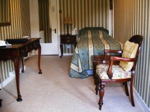 a bedroom with a bed and two chairs and a desk at The Prince's House Hotel in Glenfinnan