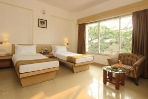Posteľ alebo postele v izbe v ubytovaní Hotel Phoenix Koregaon Park