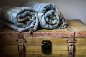two blankets sitting on top of a wooden trunk at Hooton Pagnell Hall in Doncaster