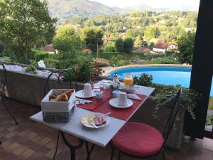 a table with breakfast food and a view of a pool at Guest house Maison Iratzean in Ascain