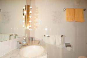 a bathroom with a sink and a mirror and towels at Hotel zum Schiffchen in Wolfhagen