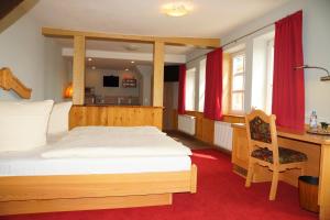 ein Schlafzimmer mit einem Holzbett und einem Schreibtisch mit einem Schreibtisch in der Unterkunft Hotel zum Schiffchen in Wolfhagen