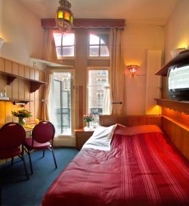 a room with a bed, a chair and a window at Nadia Hotel in Amsterdam