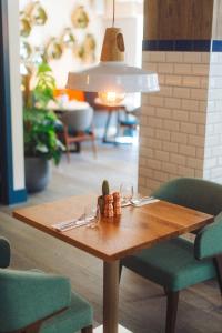 a wooden table with wine glasses and aendant light at The Corner London City in London