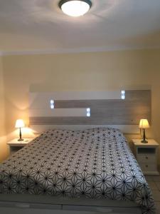 una camera da letto con un grande letto con due comodini di Apartamentos Rocas del Mar a Costa Del Silencio