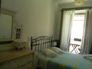 a bedroom with a bed and a dresser and a window at New Aljubarrota Guest House in Lisbon
