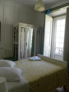 1 dormitorio con 2 camas y ventana grande en New Aljubarrota Guest House, en Lisboa