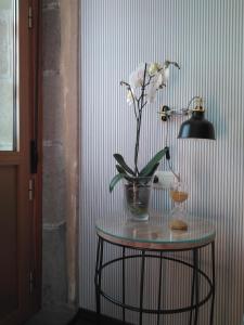 a table with a vase of flowers and a lamp at St. Peter HOME in Santiago de Compostela