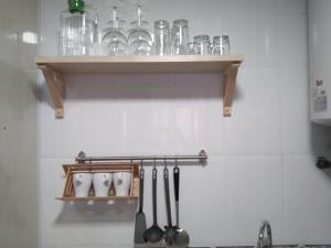 un estante con vasos y utensilios en la pared en St. Peter HOME, en Santiago de Compostela