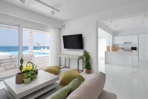 a living room with a couch and a table and a kitchen at Maria & Nada Beachfront Villas in Kolimbia