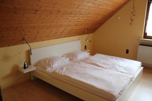 モンシャウにあるRoder am Eifelsteigの木製の天井のベッドルーム1室(白いベッド1台付)