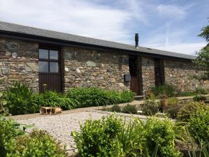 un gato tirado en el suelo frente a un edificio en The Barn, Lower Spring, en Tavistock