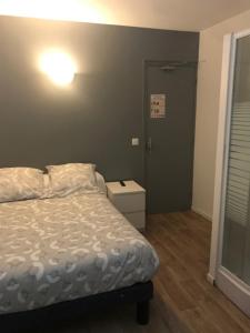 a bedroom with a bed and a door with a window at L'ENTRE-POTS in Sartrouville