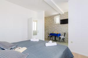a bedroom with a blue bed and a table at Miracle Apartments in Dubrovnik