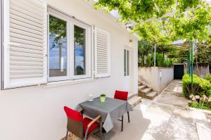 eine Terrasse mit einem Tisch, Stühlen und einem Fenster in der Unterkunft Miracle Apartments in Dubrovnik